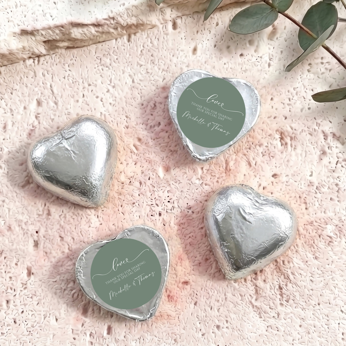 Silver foil-covered heart chocolates with round personalized thank-you labels