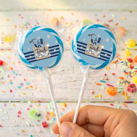 Personalised Father’s Day lollipops with blue “Dad” tools logos, clear-wrapped sticks in hand