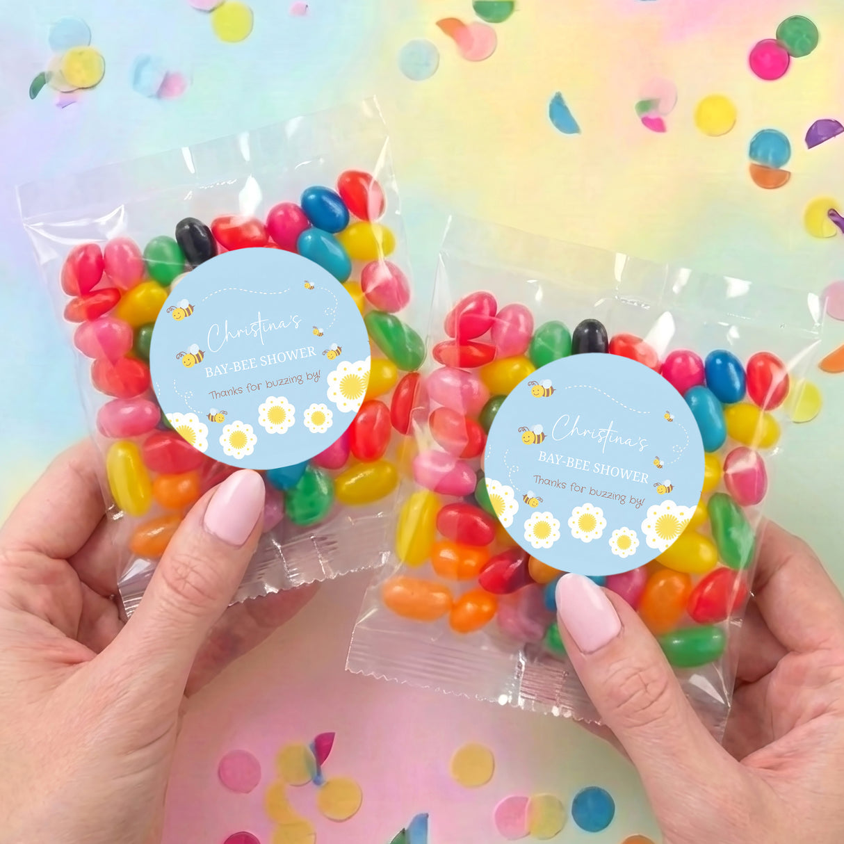 Two personalised jelly bean bags with blue round labels, held with multicolour sweets