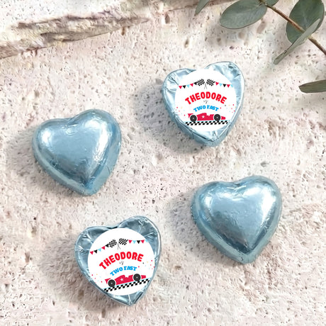 Light blue foil-covered chocolate heart with “THEODORE TWO FAST” label