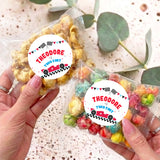 Personalised popcorn bags with colorful kernels and round race-car labels reading Theodore