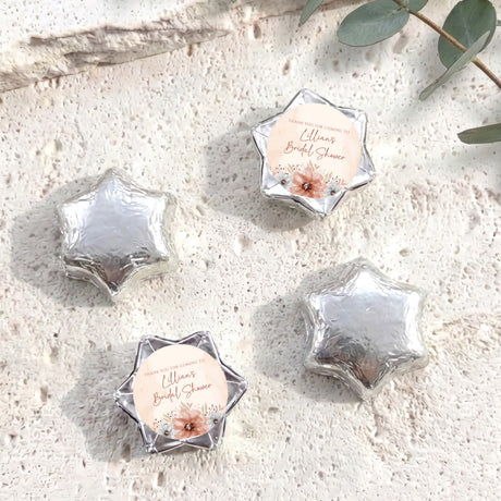 Silver foil-covered chocolate stars with floral bridal shower message labels