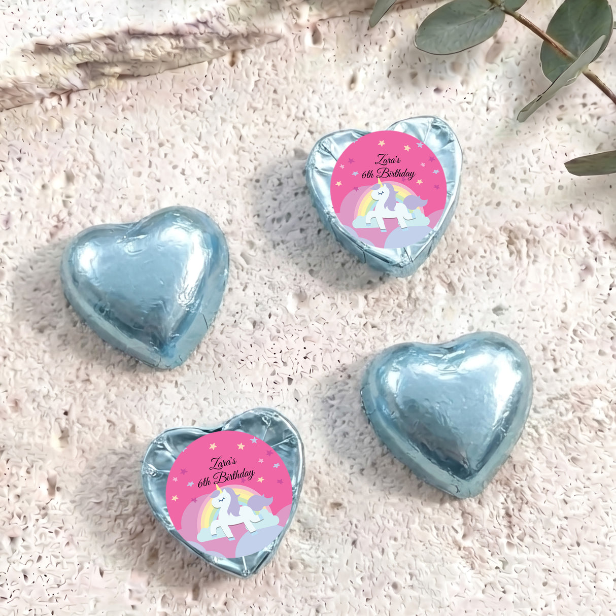 Light blue foil chocolate hearts with unicorn “Zara’s 6th Birthday” label.