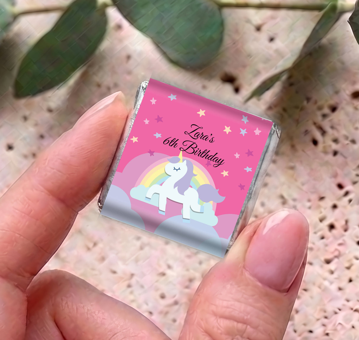 Hands holding a personalised unicorn rainbow mini chocolate for 60th birthday