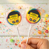 Personalised birthday lollipops with yellow truck labels in teal borders, held in hand