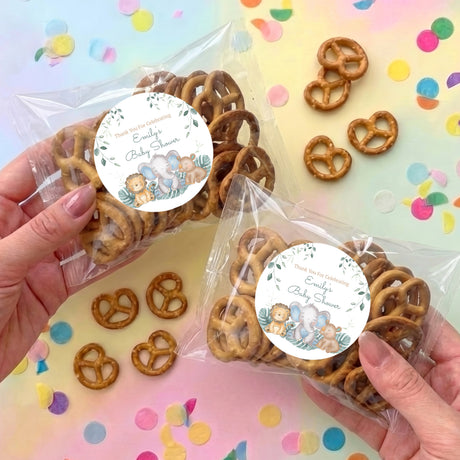 Clear pretzel bag favors with circular personalised baby shower label and safari animal art