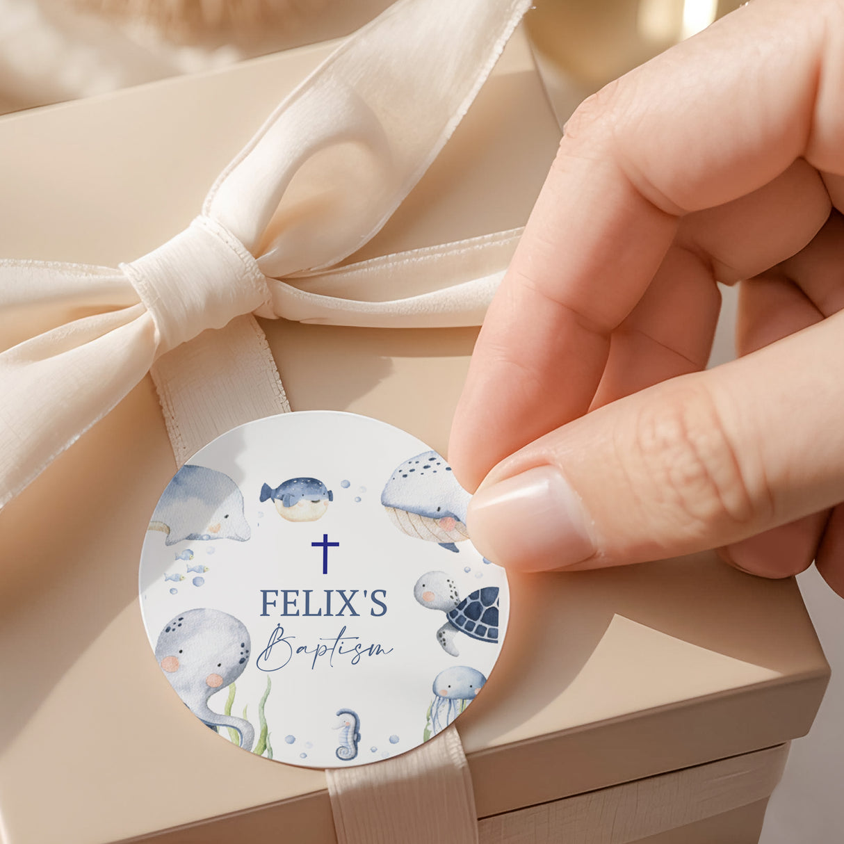 Round baptism label with sea animals, cross, and Felix’s Baptism text
