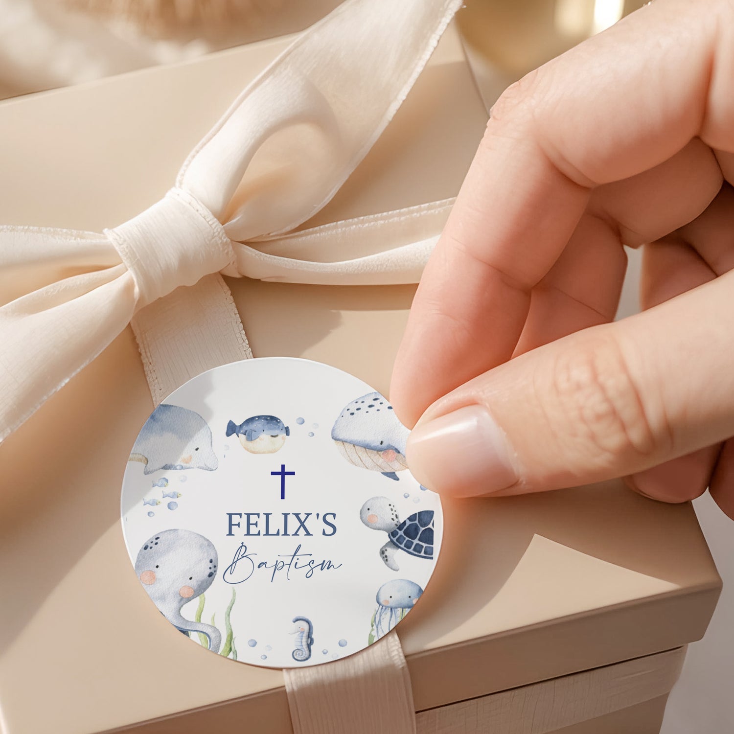 Round baptism label with sea animals, cross, and Felix’s Baptism text