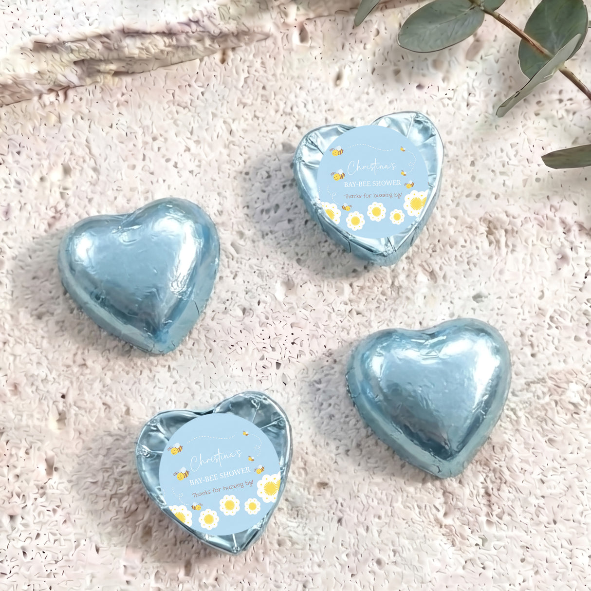 Blue foil-covered chocolate hearts with “Baby Bee Shower” gift card labels