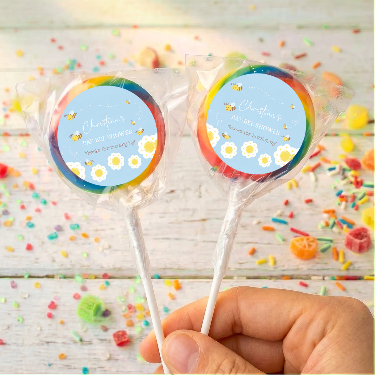 Personalised bee baby shower lollipops with rainbow-edged labels, two clear-wrapped lollipops