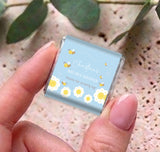 Hand holding a blue mini personalized chocolate box with “Bay-Bee Shower” bee theme