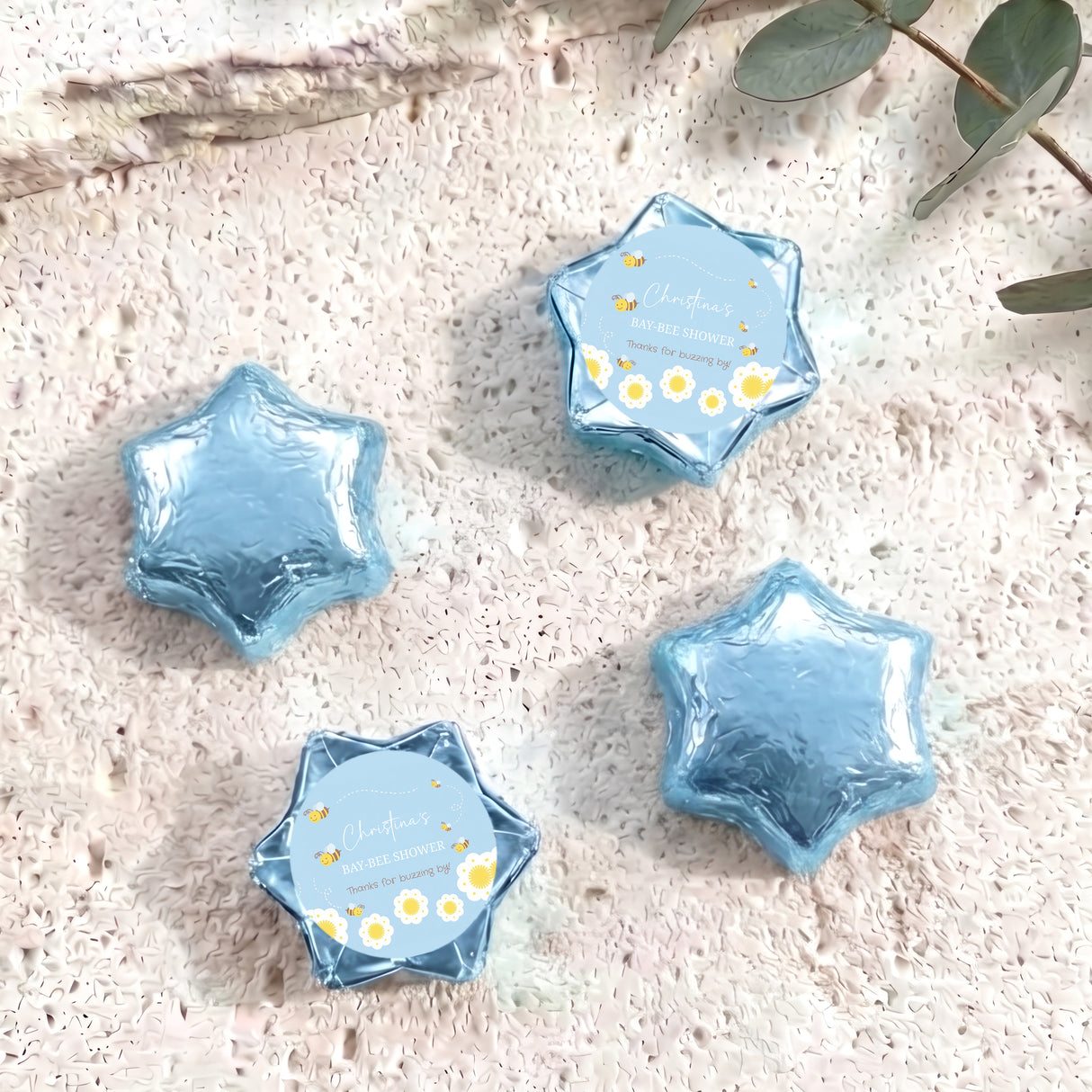 Blue foil-covered star chocolates with round personalised baby shower label