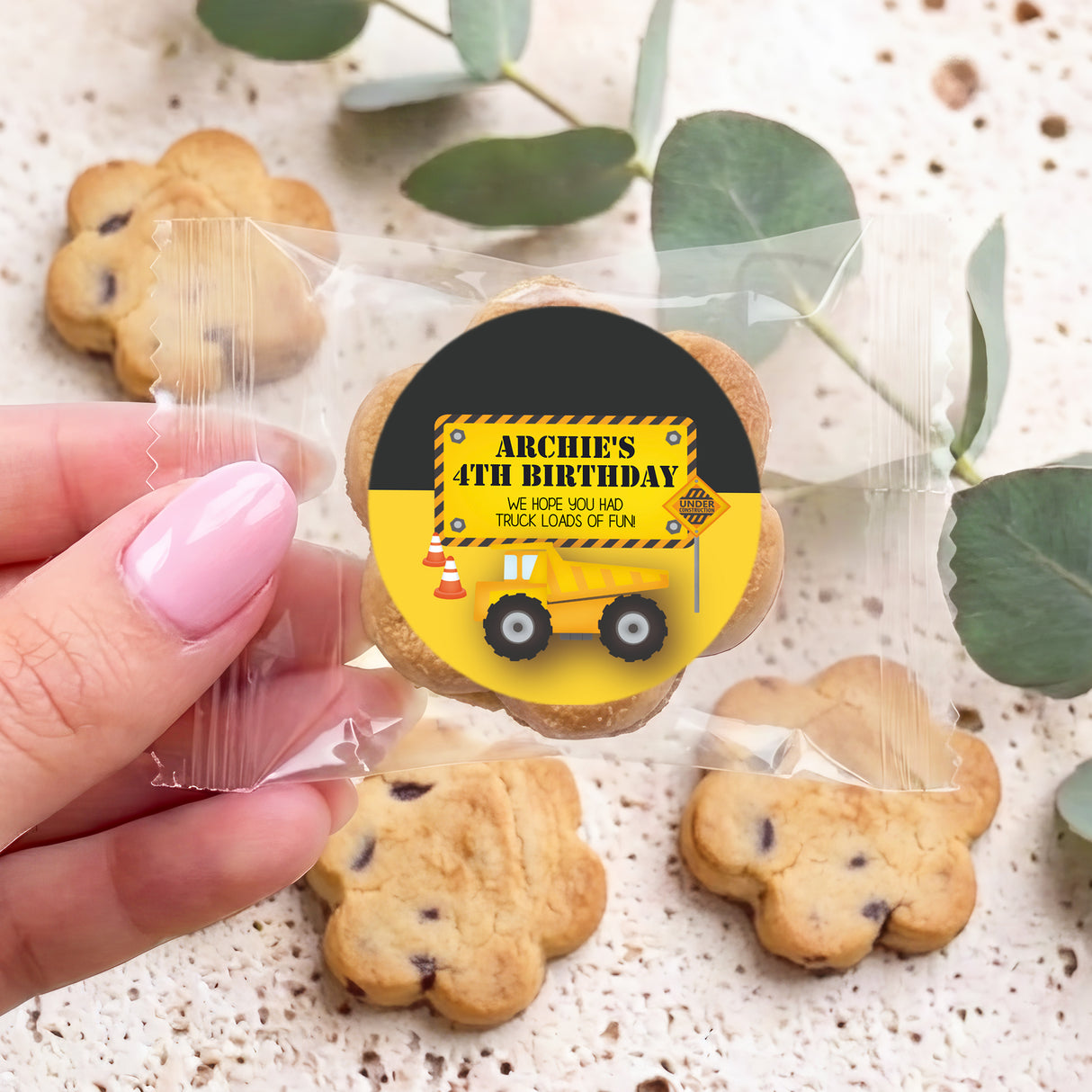 Bite-size chocolate chip cookies with truck birthday sticker on a yellow cookie
