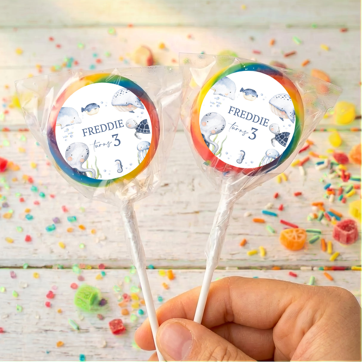 Personalised sea lollipops: two rainbow-bordered round wrappers with Freddie and age 3
