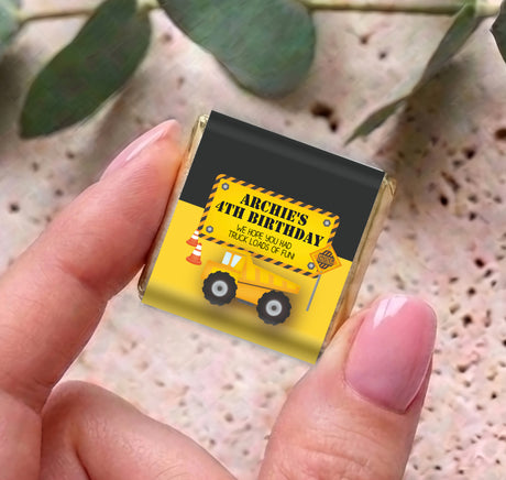 Personalised mini chocolate bar in foil with yellow truck birthday wrapper, held in hand