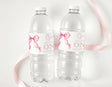 Set of two clear plastic water bottles with pink ribbon bows and printed birthday label