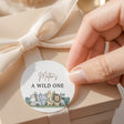 Wild One round label with “A WILD ONE” text and cute jungle animal graphic