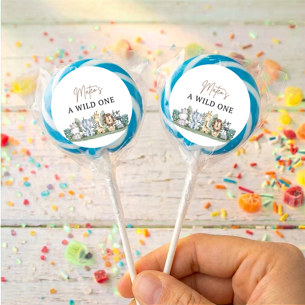 Personalised lollipop set, “A WILD ONE” labels with animal jungle graphics, blue ribbon
