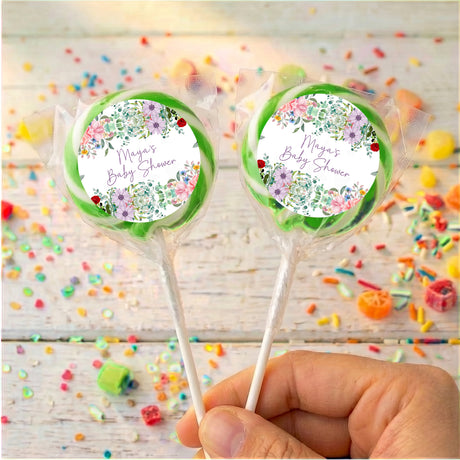 Personalised baby shower lollipops with green-edged wrappers and floral name labels