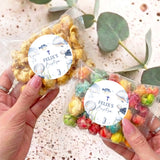 Personalised popcorn bag with round baptism label and sea-animal design, clear plastic wrap