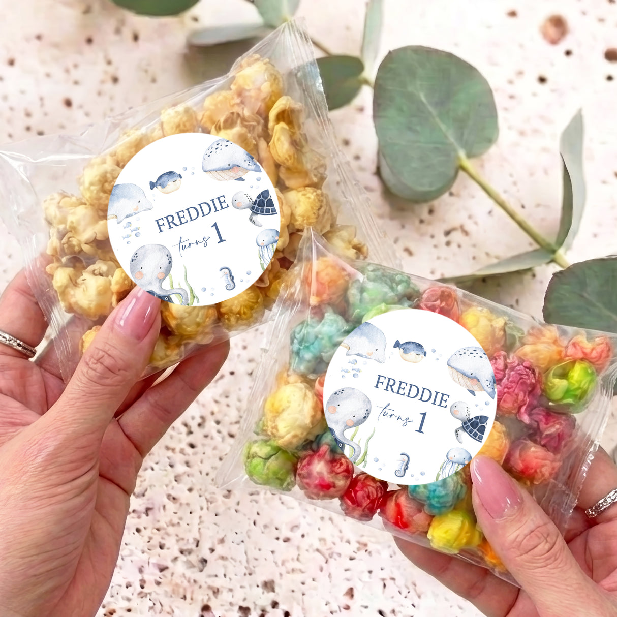 Personalised popcorn bag with clear pouch, colorful popcorn, and round blue Freddie label