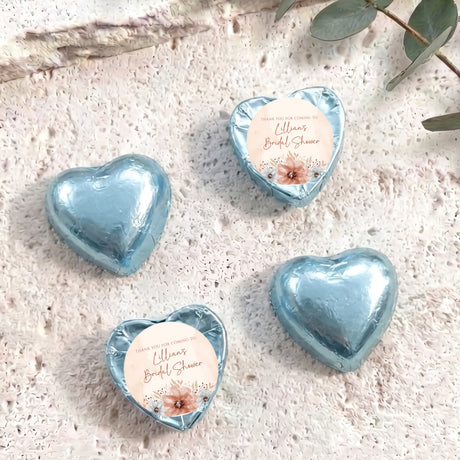 Light blue foil-covered heart chocolate favors with printed thank-you label for bridal shower