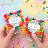 Two personalised jelly bean bags with floral confirmation labels, held in hands