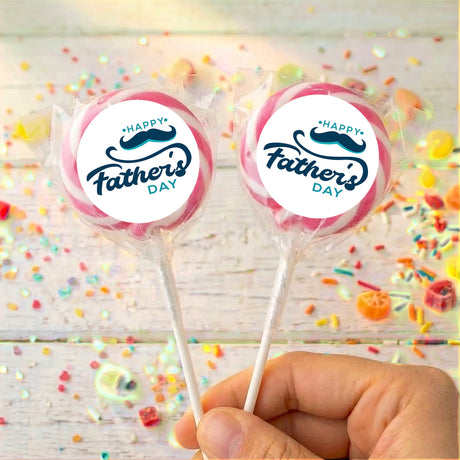 Father's Day lollipops with pink-edged 'Happy Father's Day' labels, clear wrapper, held in hand