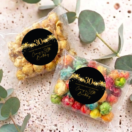 Two personalised 30th birthday popcorn bags with black gold star round labels
