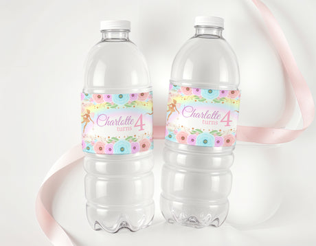 Personalised rainbow fairy birthday water bottle labels on two clear plastic bottles