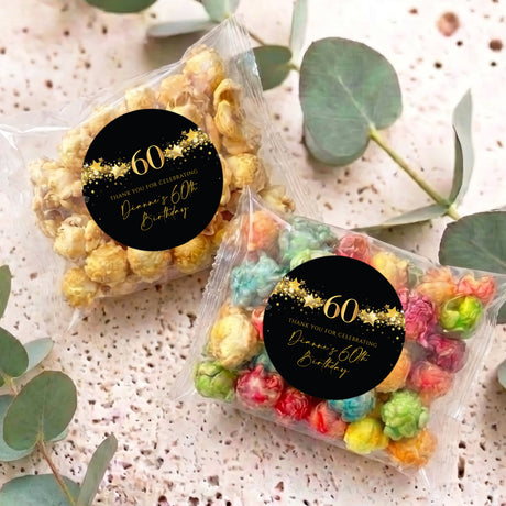 Two clear popcorn bags with black & gold 60th birthday personalised stickers