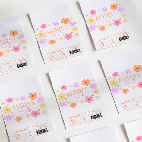 Set of white chocolate wrappers with colorful daisy and flower print and 'AUDREY' text