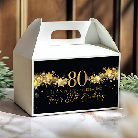 White gable favour box with gold star pattern, black front showing “80” and “Thank you”
