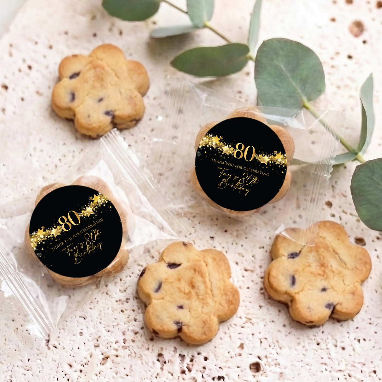 Assorted choc chip cookies in clear bags with two 80th birthday black & gold star labels
