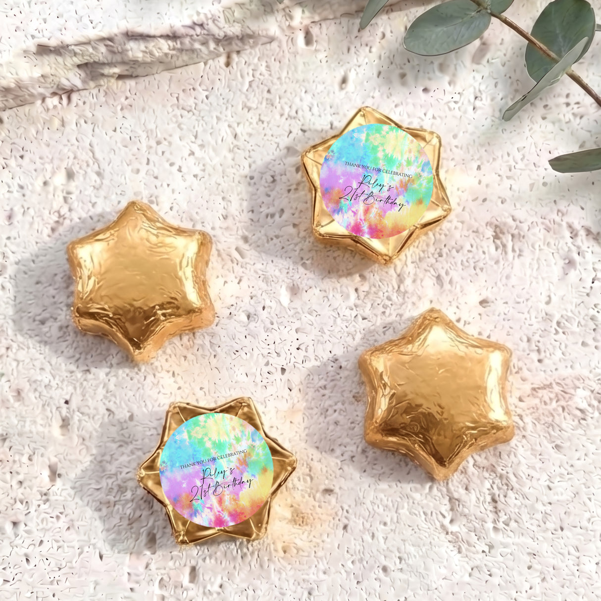 Foil-covered star chocolates in gold with one pastel tie-dye foil star