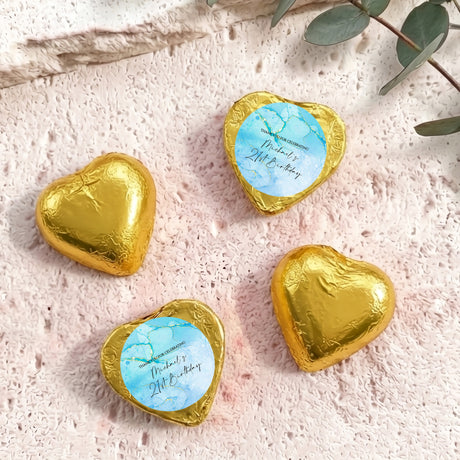 Foil-covered chocolate hearts in gold, each with a printed birthday message.