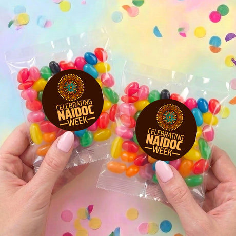 Two personalised jelly bean bags with Celebrating NAIDOC WEEK badges and mixed sweets