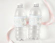 Personalised first birthday labels on two clear plastic water bottles, blue 'ONE' text