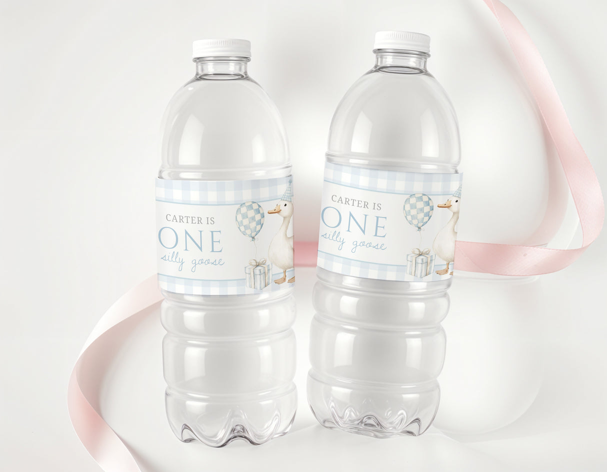 Personalised first birthday labels on two clear plastic water bottles, blue 'ONE' text