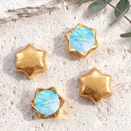 Gold foil-wrapped chocolate stars, six-point shapes with blue center label.