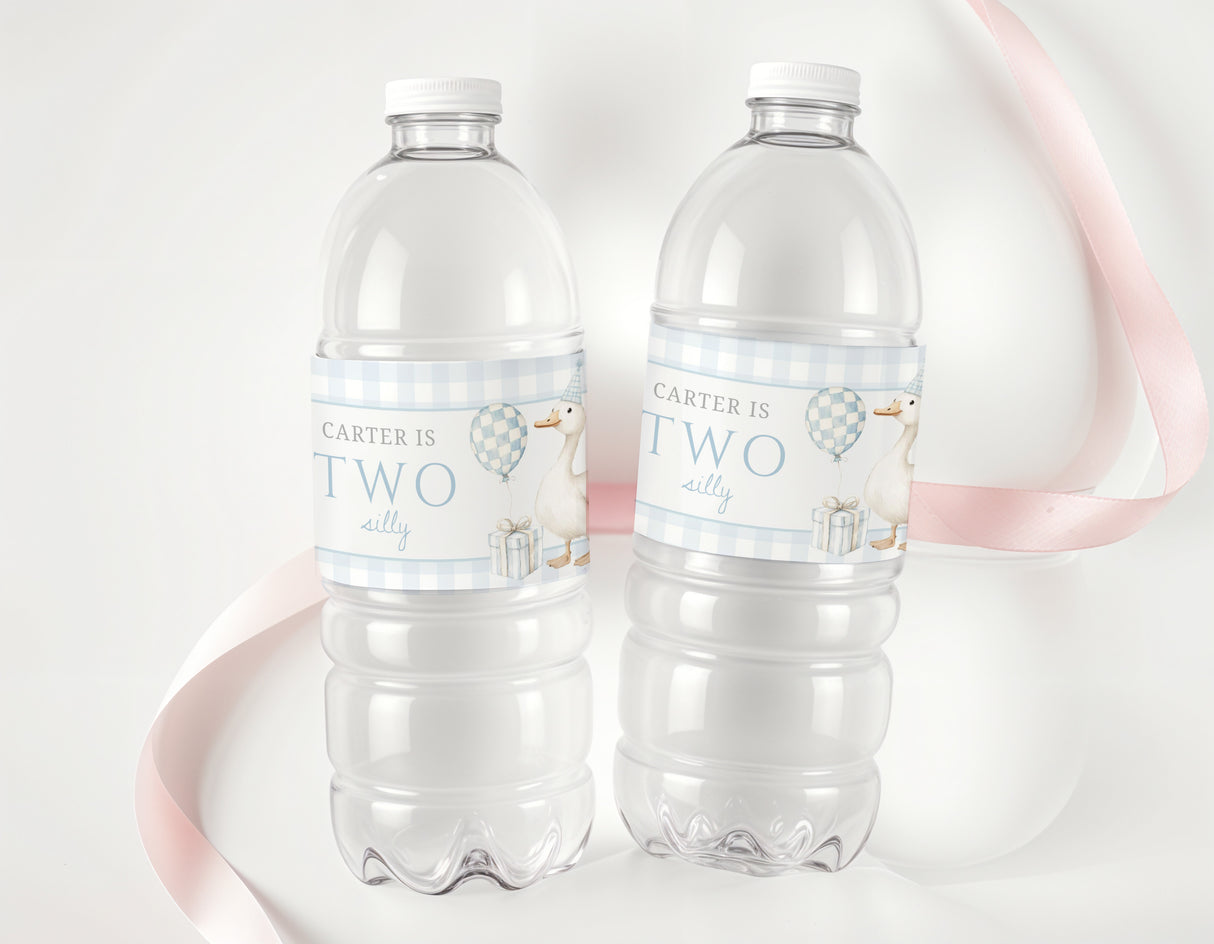 Personalised bottle labels with blue 'Carter is Two' on clear water bottles
