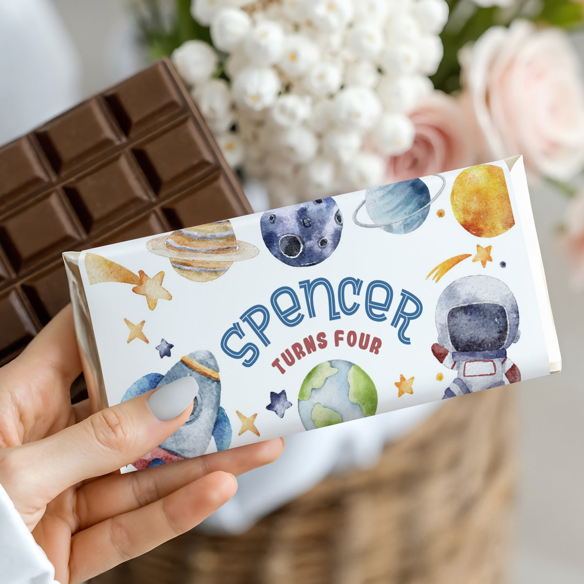Space-themed chocolate bar wrapper with planets, rocket, and Spencer turns four text