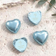 Blue foil-covered chocolate hearts with cross and name label on top.