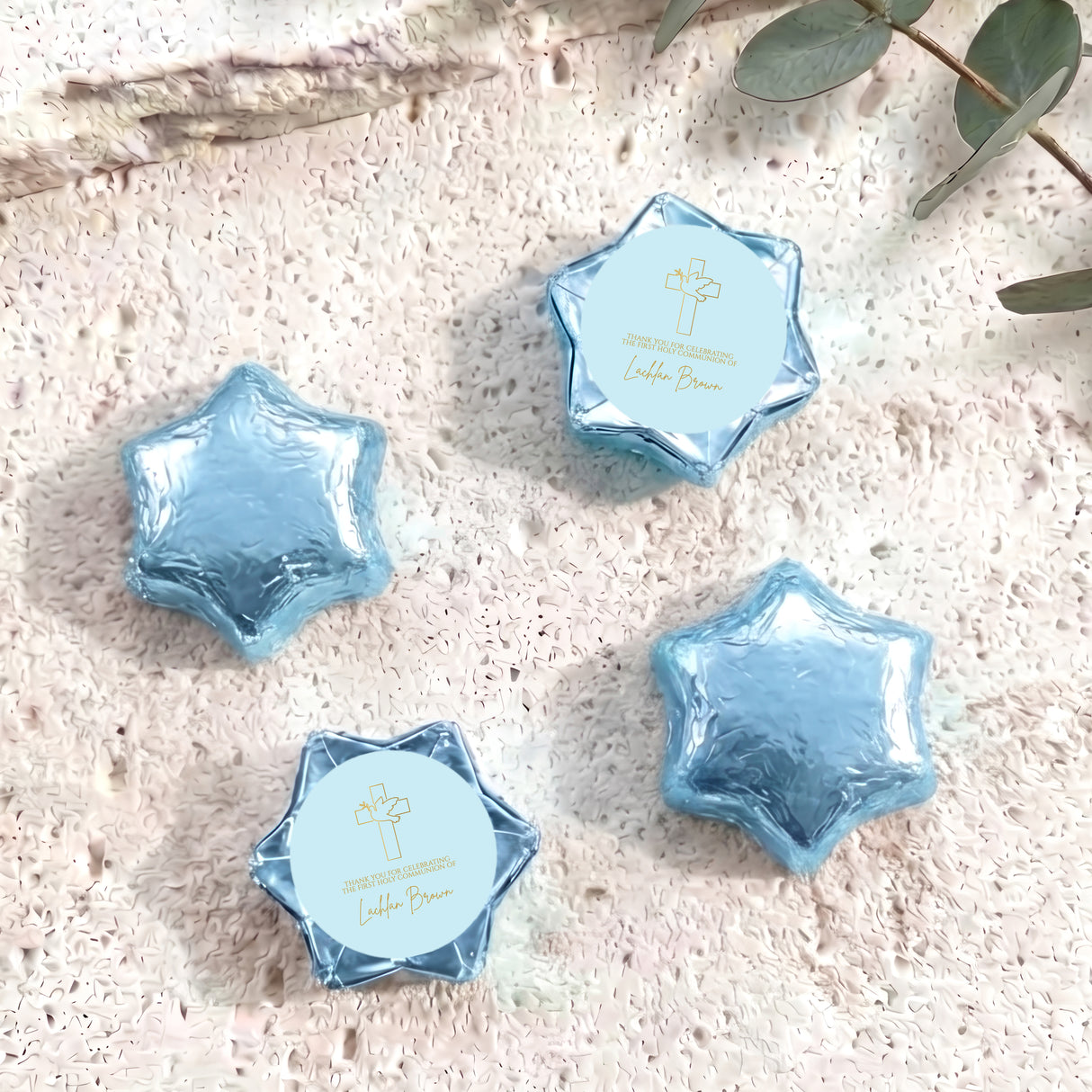 Foil-covered chocolate stars with blue wrappers and white First Communion cross labels.
