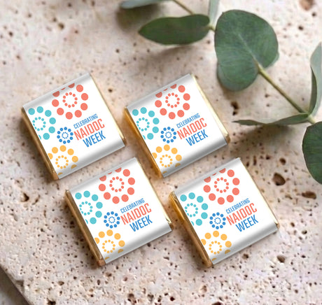 Mini chocolate boxes with pastel dot designs and 'Celebrating NAIDOC Week' text