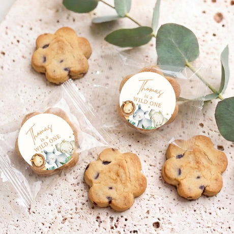 Bite-size chocolate chip cookies with round 'wild one' seals on parchment
