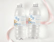 Two clear plastic water bottles with blue teddy bear birthday labels and balloons