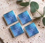 Four blue mini chocolates with gold cross and confirmation messages, arranged on display