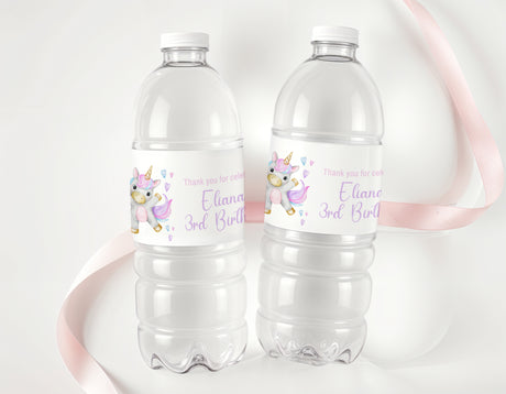 Personalised unicorn birthday water bottle labels on two clear plastic bottles