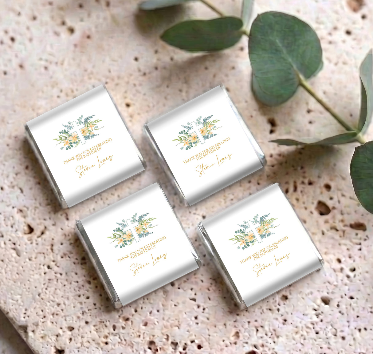 Four floral cross baptism personalised mini chocolates with silver foil, on speckled surface